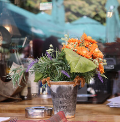 A bouquet of autumn flowers and reflections in the restaurant window.