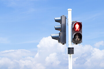 Traffic lights with green or red light lit hanging on steel pole with blue sky cloud white is background. Sign or symbol pedestrians not allowed crossing road. Safety with people to travel.