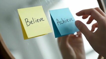 Person Places Yellow Sticky Note With The Word Believe On Mirror As A Motivational Reminder
