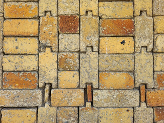 Close up of yellow and orange textured brick wall with interlocking pattern