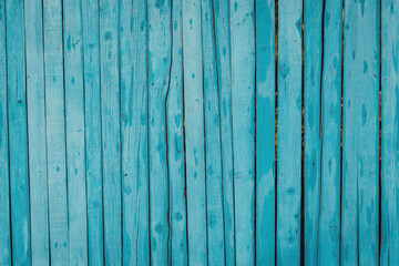 Naklejka premium Vibrant turquoise wooden planks create a soothing backdrop in a sunny coastal setting during the afternoon hours