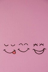The joyful emotion of love and success is represented by three smiling faces on a soft pink background. Emotions, joy, happiness