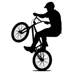 Fototapeta premium Silhouette of a BMX rider performing a wheelie trick.