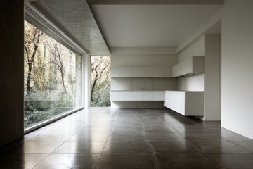 Obraz premium A spacious, modern kitchen with large windows offers a tranquil view of the surrounding trees.