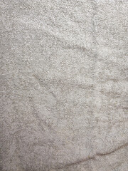Close up of textured beige towel fabric showing soft cotton fibers