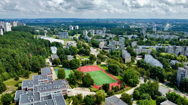 Aerial view of Lazdynai, Vilnius, showcasing mid-rise, rectangular Soviet-era apartment buildings. The architecture is characterized by uniformity and functionality, with greenery 