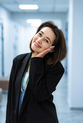 Smiling woman in clinic hallway. Young woman in casual and formal wear smiling in a hospital or clinic hallway.