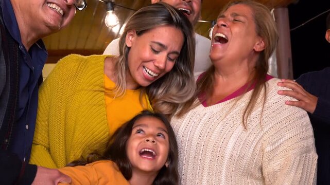 Hapy latin family smiling on camera during night time - Grandparents, parents and children - Multi generational people