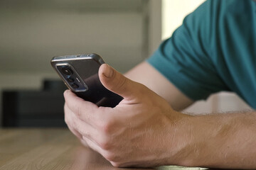Man using his cellphone. Handsome guy use mobile phone at home. Male browses social networks, gaming, does shopping online, chats with friends, writes or reads messages. Close up. 4k video footage