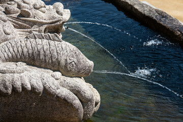 stone sculpture fountain with water streams at the Buddhist temple