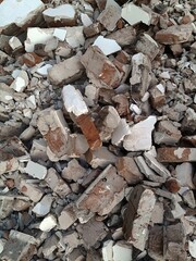 A pile of broken red bricks and fragments of concrete. Pile of debris of a torn down building