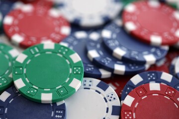 Close up of a group of casino chips on a green mat for poker or dice games indoors