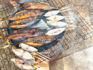 A smoky shot of freshly smoked fish on a barbeque, perfect for a summer cookout or traditional...