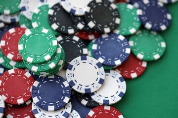 Close up of a group of casino chips on a green mat for poker or dice games indoors
