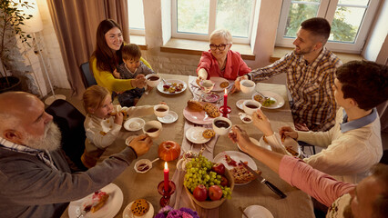 Generational family toast with tea around cozy holiday table full of warmth. Concept of heritage,...