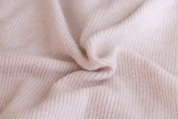 Texture of knitted pastel pink sweater, close-up texture of beige pink