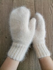 Stack of cozy knitted sweaters and accessories in soft pastel tones. Winter fashion collection, slow fashion and handmade design.