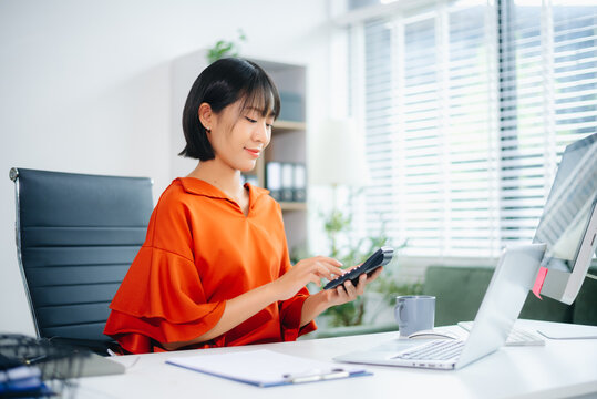 Confident business expert attractive smiling young woman typing laptop and holding digital tablet - Powered by Adobe