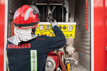 Unrecognizable Firefighter check and maintenance equipment near fire truck. High quality photography