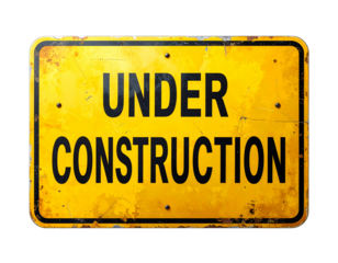 A weathered yellow sign displaying the words "UNDER CONSTRUCTION" in bold black letters.