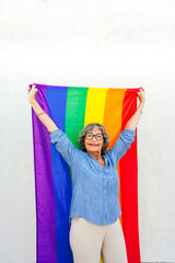 Senior woman celebrating lgbtq rights holding rainbow flag