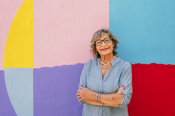 Senior woman smiling on colorful mural background