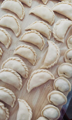 Golden-hued pierogi lay snugly nestled on rustic board, celebrating Eastern European grandmothers' delights and Dumpling Day festivities