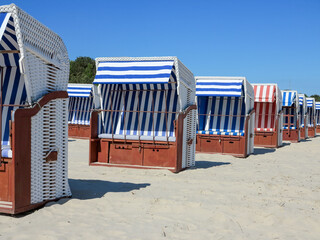 A Low-Angle View of Strandkorb Beach Chairs on a Sunny Shore