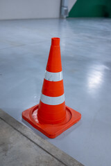 Bright Orange Safety Cone: Vertical close-up for designers, showing a striped traffic pylon used...