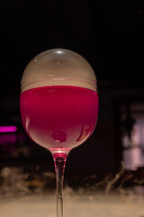 Molecular Cocktail with Vivid Pink Liquid and Smoke Bubble in a Coupe Glass, Experimental Bar Drink, Futuristic Mixology, Dramatic Nightclub Beverage Stock