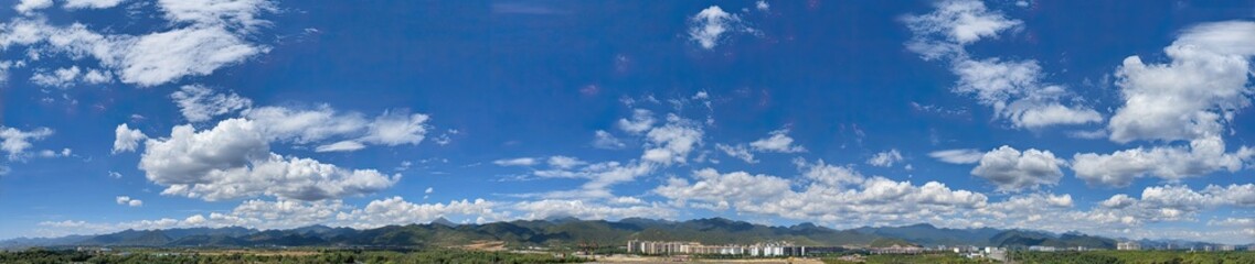 Naklejka premium Panoramic view of a partly cloudy sky over rolling hills