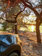 Car parked by lake enjoying golden hour sunset