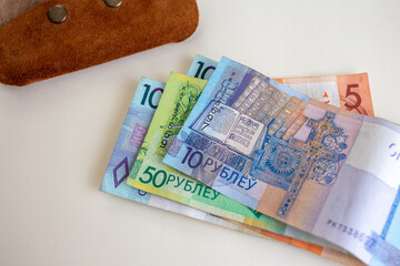 Belarusian ruble banknotes spread near suede wallet