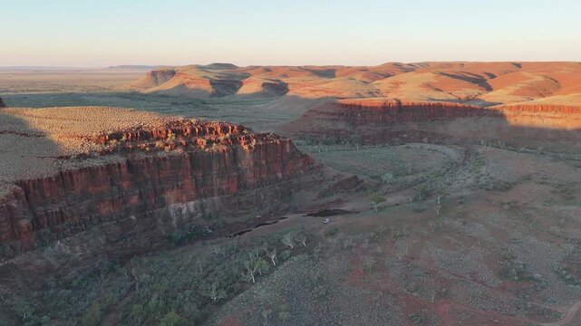 aerial drone shot of a remote bush camp along secluded George river in the beautiful red rolling hills of Millstream Chichester National Park, pilbara shire in West Australia.