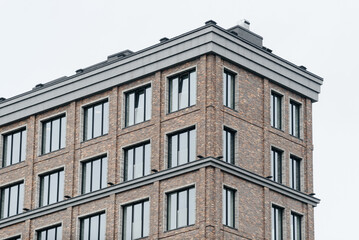 modern multi-storey apartment building, brown brick building with glass windows, urban background