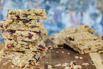 Stacked healthy oatmeal flapjacks, oatbars on rustic wooden chopping board