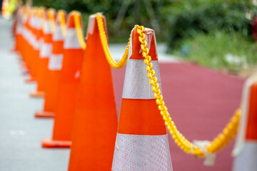 Orange Safety cones are being chained and put on the roadside