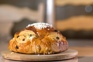 Golden raisin brioche with pearl sugar topping on a wooden board, a traditional sweet bread from northern France.
