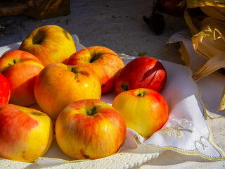 Fresh red apples on a plate next to a white napkin at the autumn exhibition 