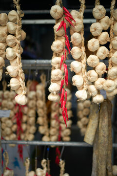 Braided garlic and red chilies hanging on display at a market. Brussels, Belgium
