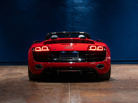 Red Audi R8 Spyder rear view with illuminated taillights, German V10 supercar in a professional studio

