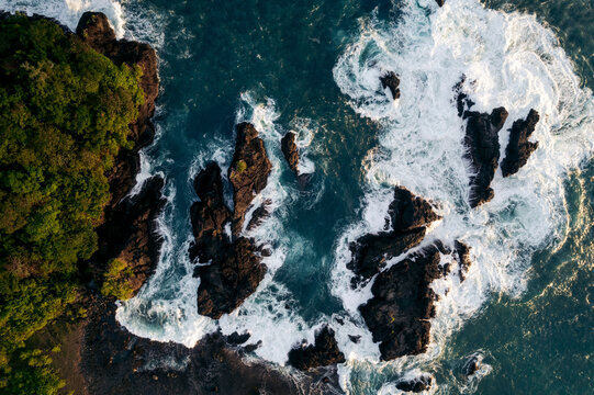 Aerial view of rugged coastline with crashing waves and lush greenery. South Nias, North Sumatra, Indonesia