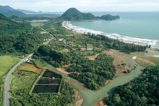 Aerial view of lush coastal landscape with winding river and distant mountains. Aceh Jaya Regency, Aceh, Sumatra, Indonesia