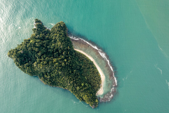 Aerial view of a small, lush green island surrounded by turquoise ocean waters. Aceh Jaya Regency, Aceh, Sumatra, Indonesia