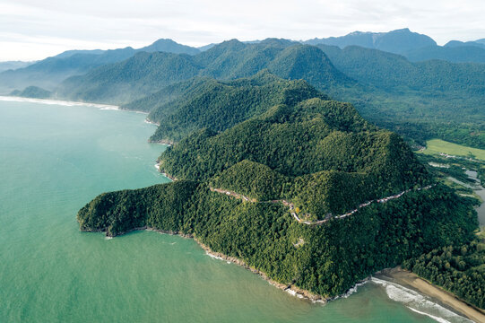 Aerial view of lush green landscape with a prominent coastal hill and vast ocean backdrop. Aceh Jaya Regency, Aceh, Sumatra, Indonesia