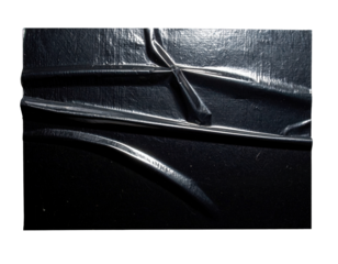 Close-up of a black tire tread pattern, showing the deep grooves and texture.