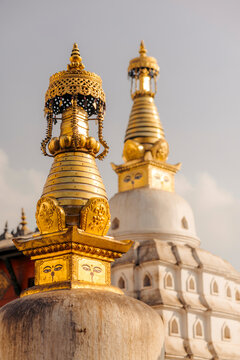 Golden and white stupas with intricate designs under a clear sky. Monkey Temple, Kathmandu, Nepal