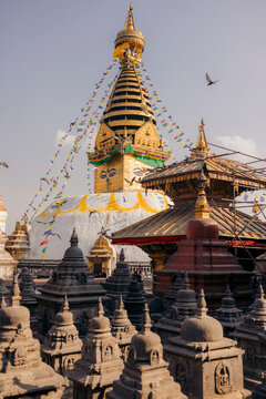 Swayambhunath Stupa with prayer flags and stone sculptures under a clear sky. Monkey Temple, Kathmandu, Nepal