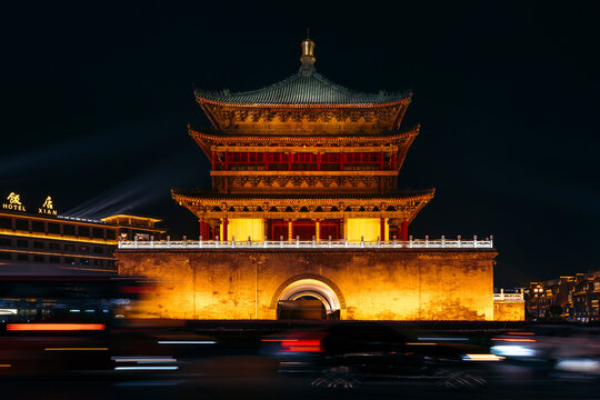 Illuminated traditional Chinese building at night with blurred motion of city lights. Bell Tower of Xi'an, China