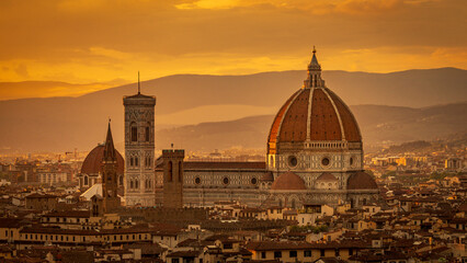 Florence skyline with the iconic Duomo, Cathedral of Santa Maria del Fiore,  at sunset against a golden sky. Florence, Italy